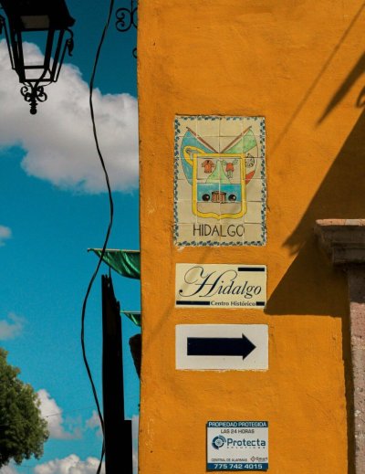 Vibrant street scene in Dolores Hidalgo with historic signage and architecture.
