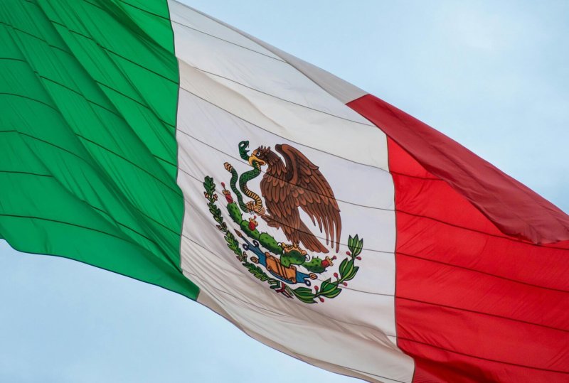Mexican flag waving in the wind, symbolizing national pride and freedom.