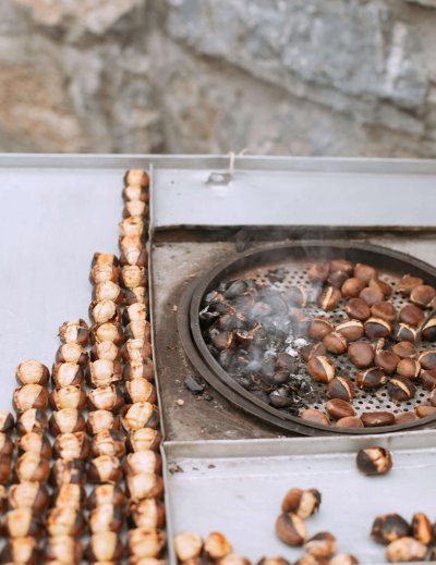 Roasted chestnuts on tray at autumn market in Barcelona