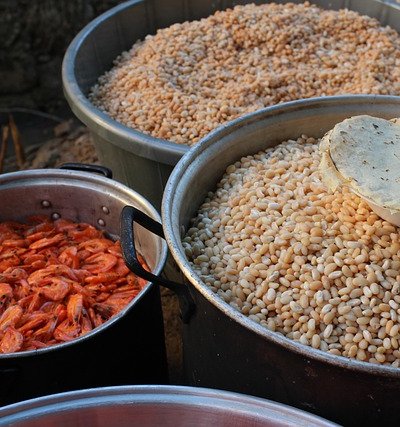 Colorful clay vessels filled with authentic Mexican ingredients including dried chiles and grains