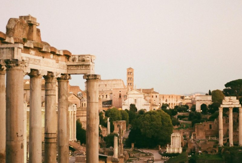 Ancient Roman Forum ruins with standing columns at sunset