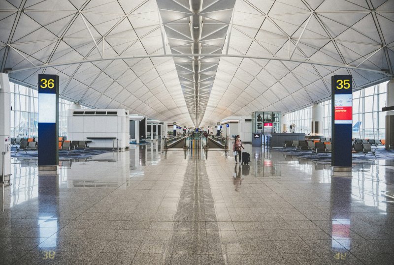 Modern airport terminal interior with departure gates and travelers walking